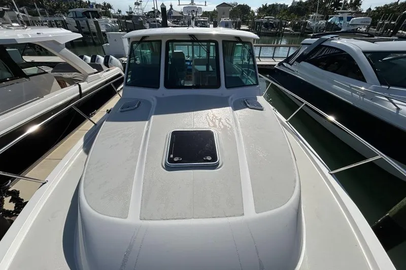 Slide: The Image of 2022 Back Cove 39O boat docked at marina, showcasing sleek design and spacious deck. - 10