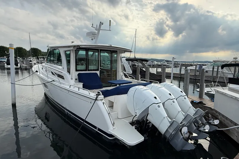 Slide: The Image of 2022 Back Cove 39O boat docked with triple outboard engines under cloudy sky. - 13