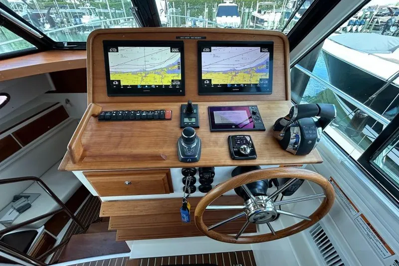 Slide: The Image of Helm of 2022 Back Cove 39O with dual navigation screens and wooden steering wheel. - 19