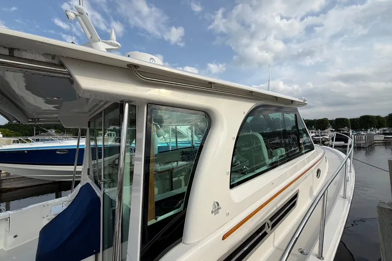 Slide: The Image of 2022 Back Cove 39O boat docked, showcasing sleek design and modern features under a cloudy sky. - 15