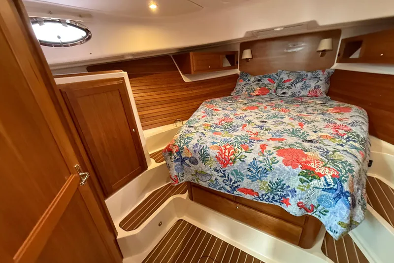 Slide: The Image of Cozy cabin interior of 2022 Back Cove 39O with floral bedding and wooden accents. - 60