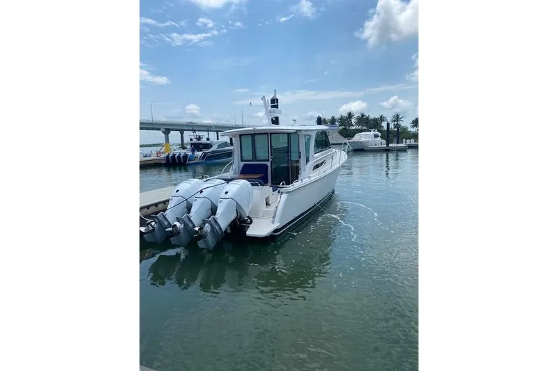 Slide: The Image of 2022 Back Cove 39O boat docked with triple outboard engines in a marina. - 4