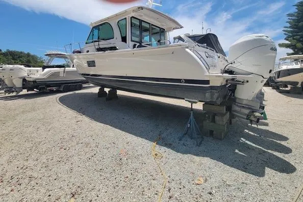 Slide: The Image of 2022 Back Cove 39O boat on dry dock, white hull, outboard engines, sunny day. - 6
