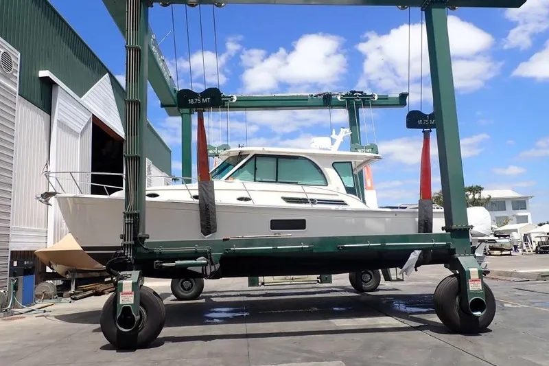 Slide: The Image of 2022 Back Cove 39O boat on a lift at a marina, clear sky background. - 7