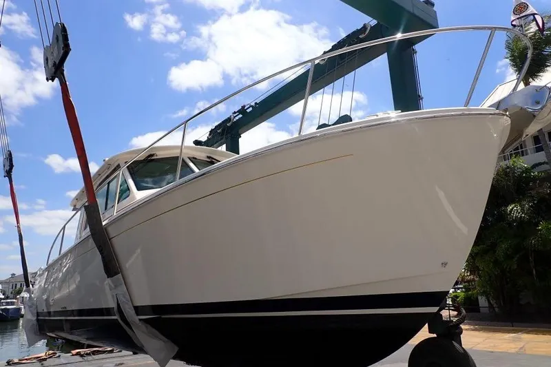 Slide: The Image of 2022 Back Cove 39O boat being lifted at a marina under a clear blue sky. - 8