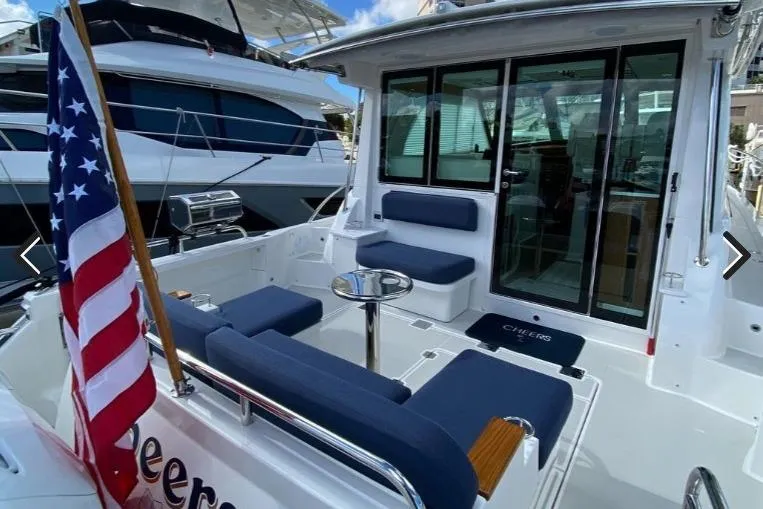 Slide: The Image of 2022 Back Cove 39O yacht with American flag, spacious seating, and sleek design. - 9