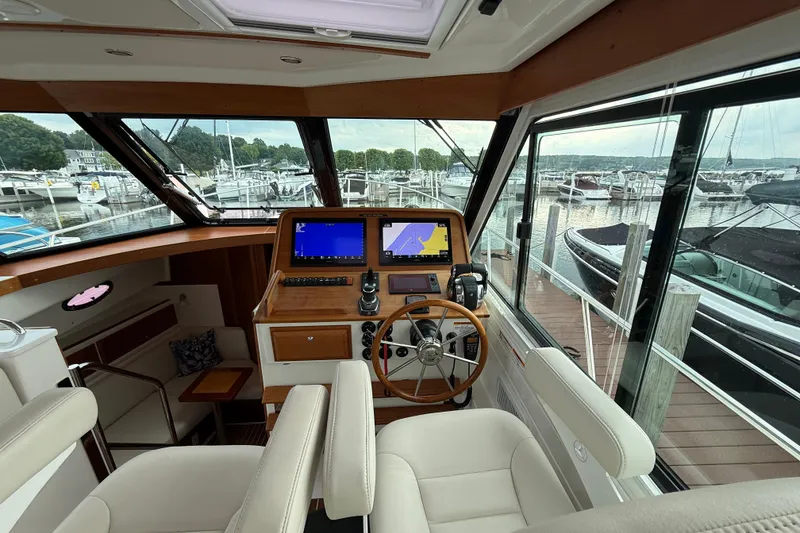 Slide: The Image of Interior view of 2022 Back Cove 39O yacht helm with marina in background. - 42