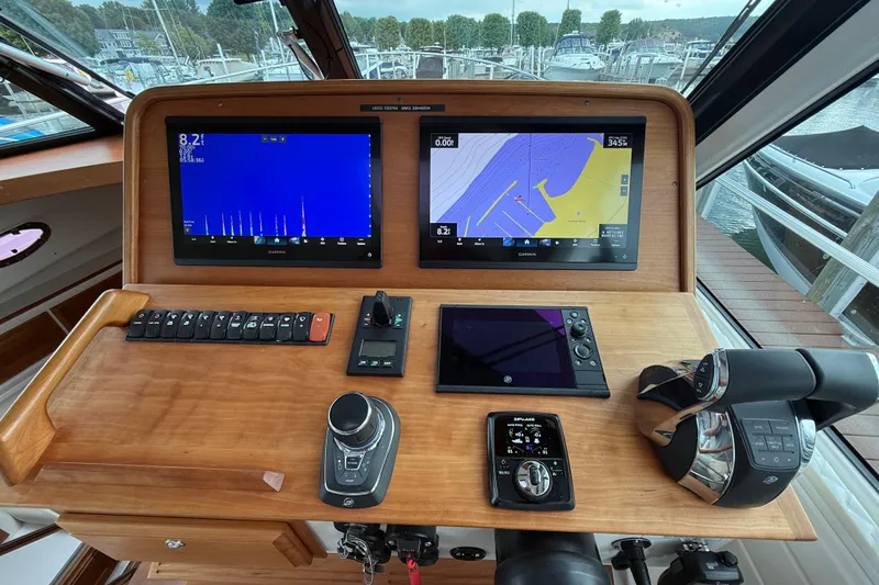 Slide: The Image of Helm of 2022 Back Cove 39O with navigation screens and controls, docked at marina. - 46