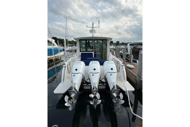 Slide: The Image of 2022 Back Cove 39O boat with triple outboard engines docked at marina. - 25