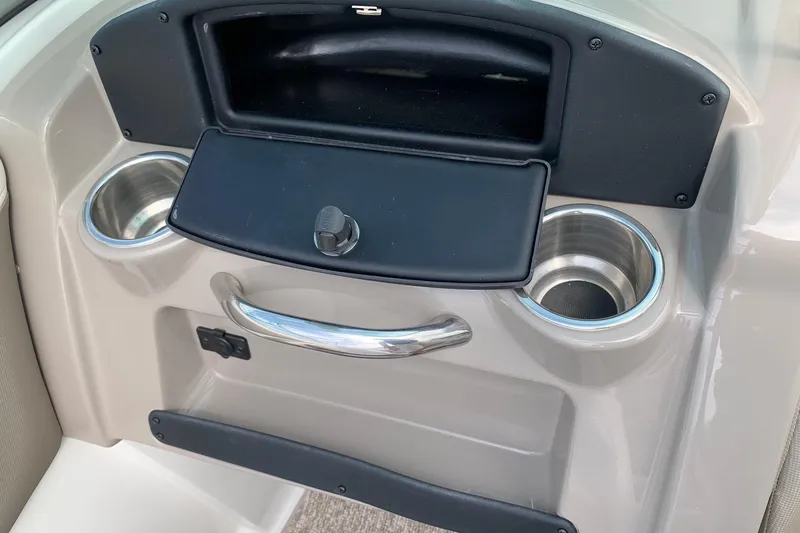 Slide: The Image of 2018 Crownline 205 SS boat dashboard with cup holders and storage compartment. - 16