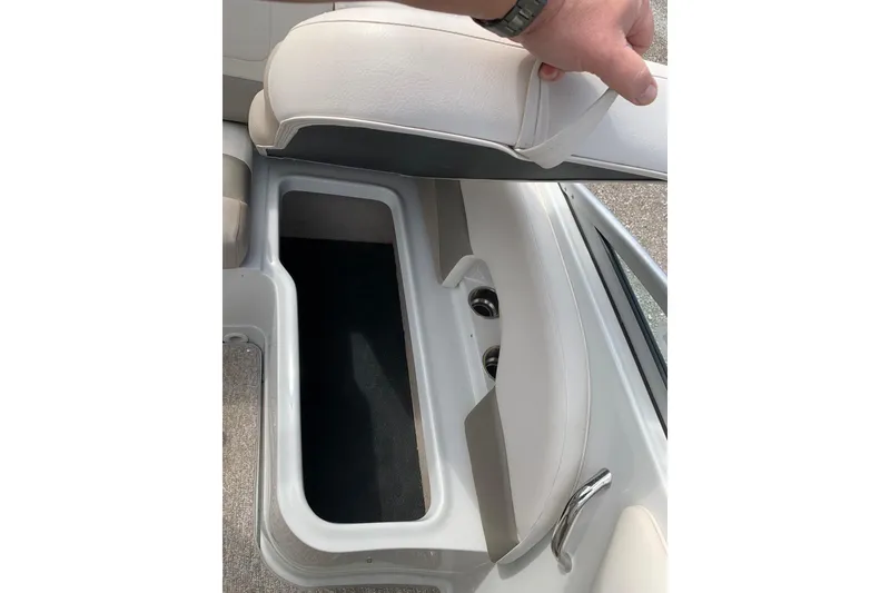 Slide: The Image of 2018 Crownline 205 SS boat seat storage compartment with open lid, showcasing interior space. - 18