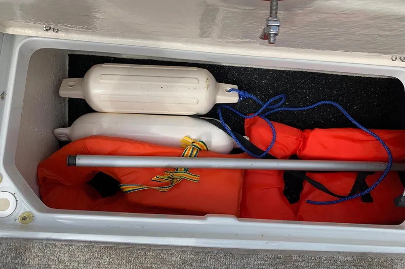 Slide: The Image of Storage compartment in 2018 Crownline 205 SS boat with life jackets and fenders. - 19
