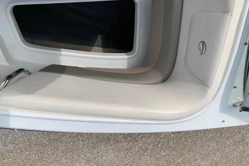 Slide: The Image of 2018 Crownline 205 SS boat interior seating with white upholstery and logo detail. - 21
