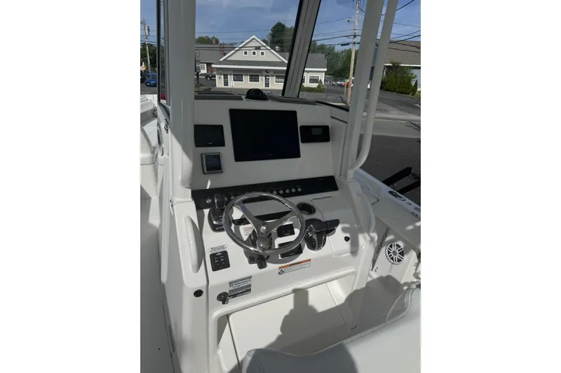 Slide: The Image of 2021 Regulator 25 boat helm with steering wheel and control panel. - 2