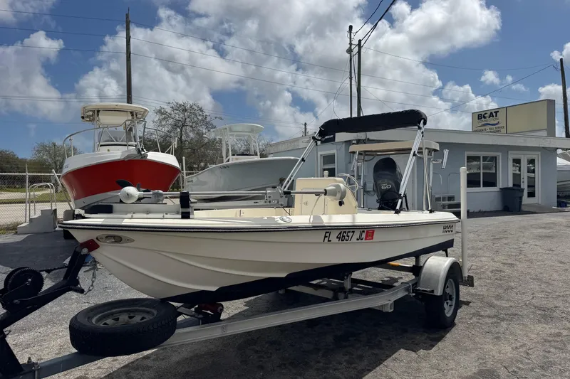 Slide: The Image of 1991 Hoog Comet 14 boat on trailer, parked outside a marine service shop under a cloudy sky. - 3