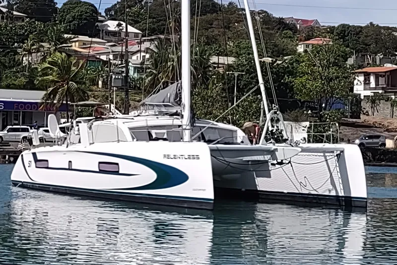 Slide: The Image of 2020 Outremer 51 catamaran docked in a scenic harbor setting. - 10