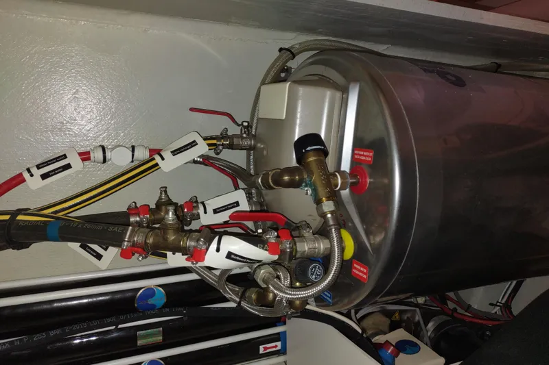 Slide: The Image of Engine room of a 2020 Outremer 51 yacht, featuring complex plumbing and wiring. - 105