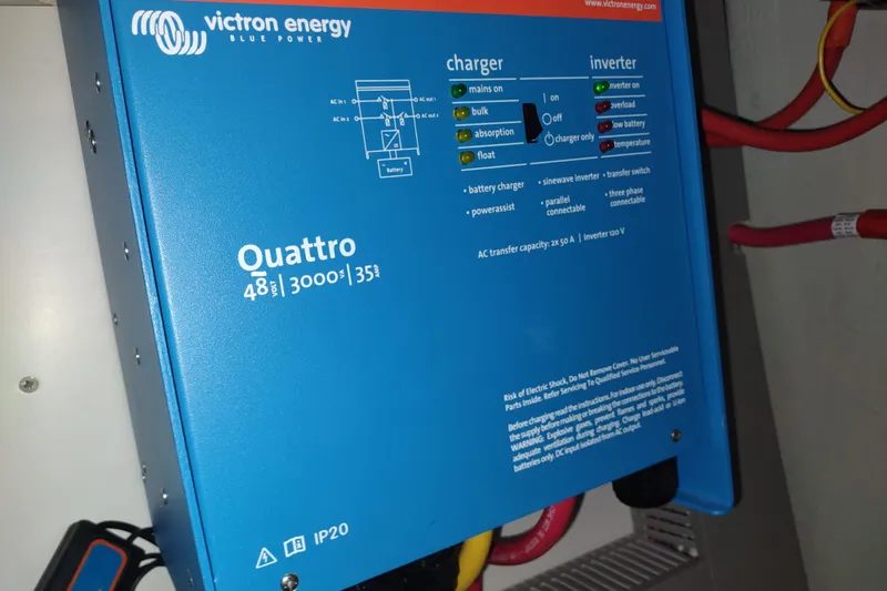 Slide: The Image of Victron Energy Quattro inverter on 2020 Outremer 51 yacht, blue casing, connected cables. - 107