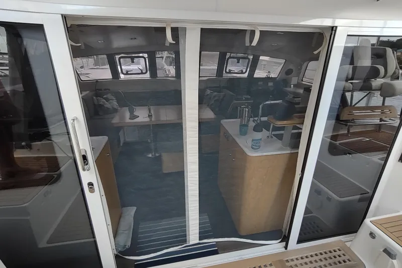 Slide: The Image of Interior view of 2020 Outremer 51 catamaran through glass doors, showcasing modern design. - 130