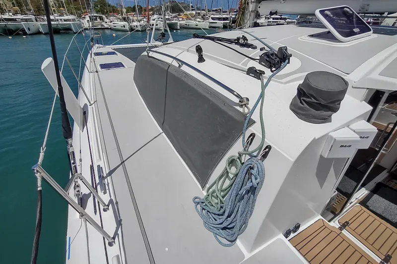 Slide: The Image of 2020 Outremer 51 catamaran deck view in marina, showcasing sleek design and rigging. - 146