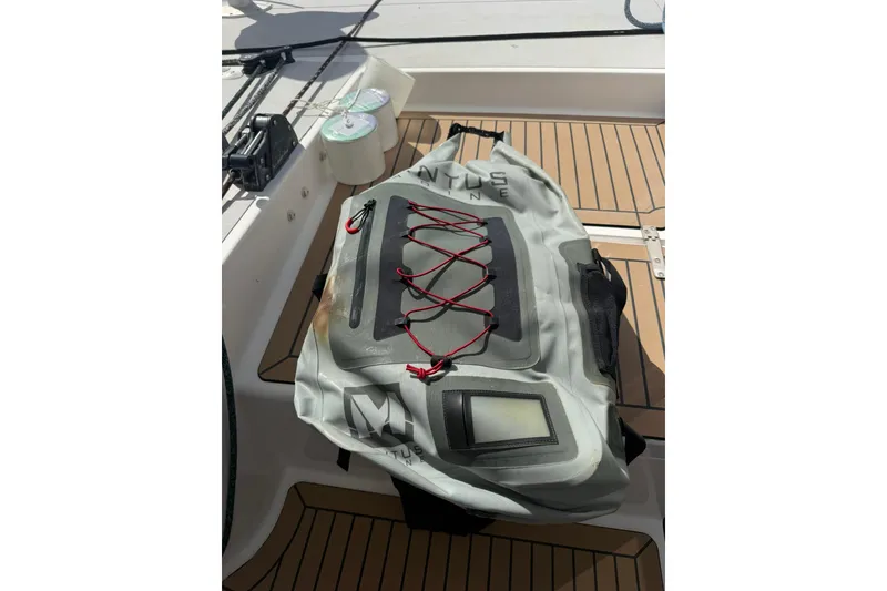 Slide: The Image of Waterproof bag on 2020 Outremer 51 yacht deck, featuring red bungee cords. - 150
