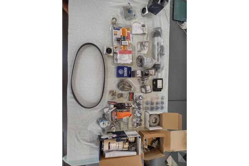 Slide: The Image of Assorted spare parts for 2020 Outremer 51 yacht, including belts and mechanical components. - 157