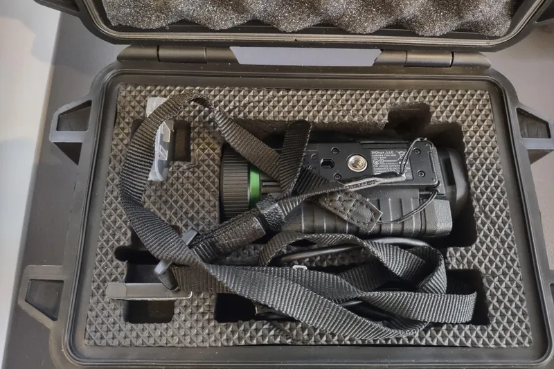 Slide: The Image of Protective case with a secured optical device, featuring foam padding and straps. - 158