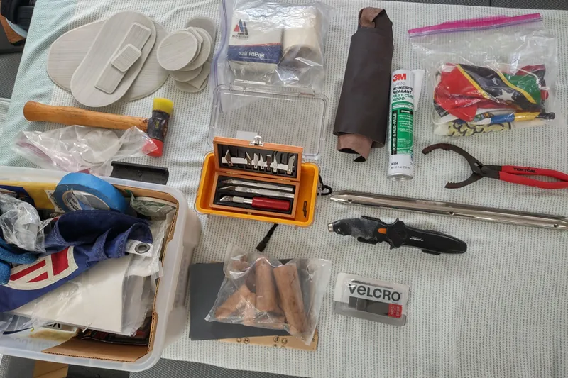 Slide: The Image of Assorted tools and supplies for Outremer 51 yacht maintenance, including sealant, pliers, and Velcro. - 164