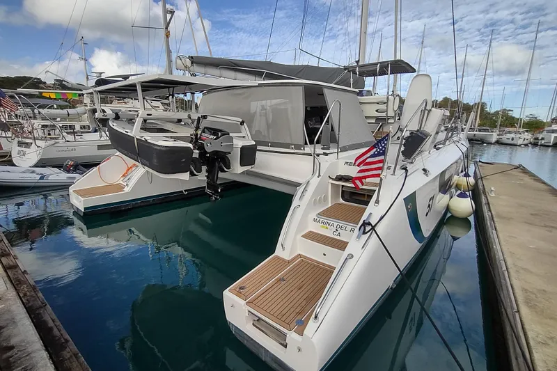 Slide: The Image of 2020 Outremer 51 catamaran docked at marina, featuring sleek design and American flag. - 18