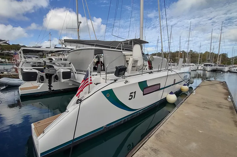 Slide: The Image of 2020 Outremer 51 catamaran docked at marina, featuring sleek design and American flag. - 19