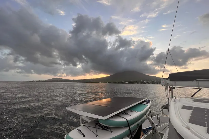 Slide: The Image of Outremer 51 catamaran sailing at sunset with dramatic clouds and mountain backdrop, 2020 model. - 201