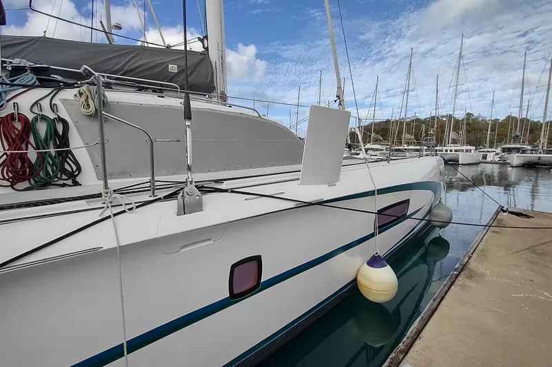 Slide: The Image of 2020 Outremer 51 catamaran docked in marina, featuring colorful ropes and fenders. - 21