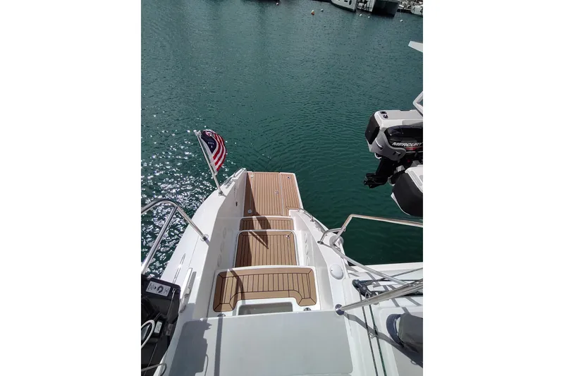 Slide: The Image of Outremer 51 catamaran 2020, rear deck view with American flag and Mercury engine. - 25