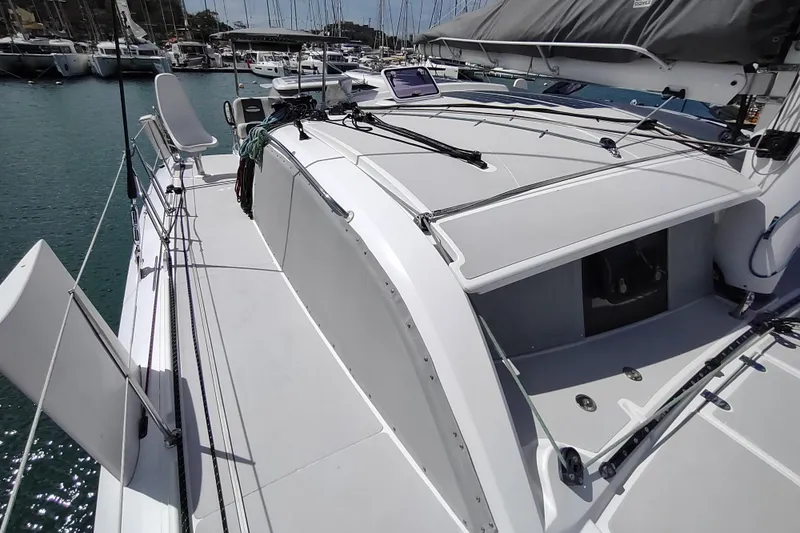 Slide: The Image of 2020 Outremer 51 sailboat deck, featuring sleek design and modern rigging in a marina setting. - 28