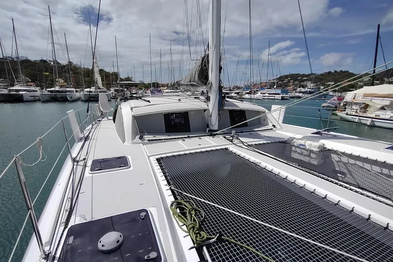 Slide: The Image of 2020 Outremer 51 catamaran docked in a marina, surrounded by other boats. - 32