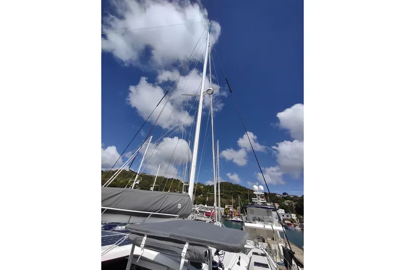 Slide: The Image of Outremer 51 sailboat, 2020 model, docked under a clear blue sky with fluffy clouds. - 36