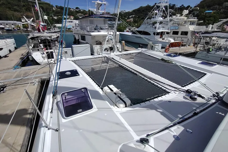 Slide: The Image of 2020 Outremer 51 catamaran docked at a marina, showcasing deck and rigging. - 39