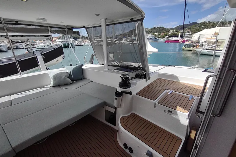 Slide: The Image of 2020 Outremer 51 yacht cockpit with seating, docked in a marina under clear skies. - 42