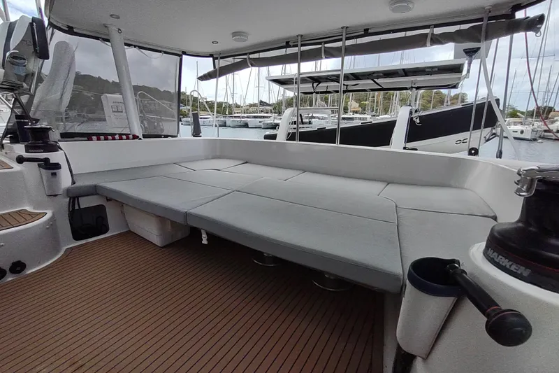 Slide: The Image of 2020 Outremer 51 catamaran cockpit with cushioned seating and marina view. - 46
