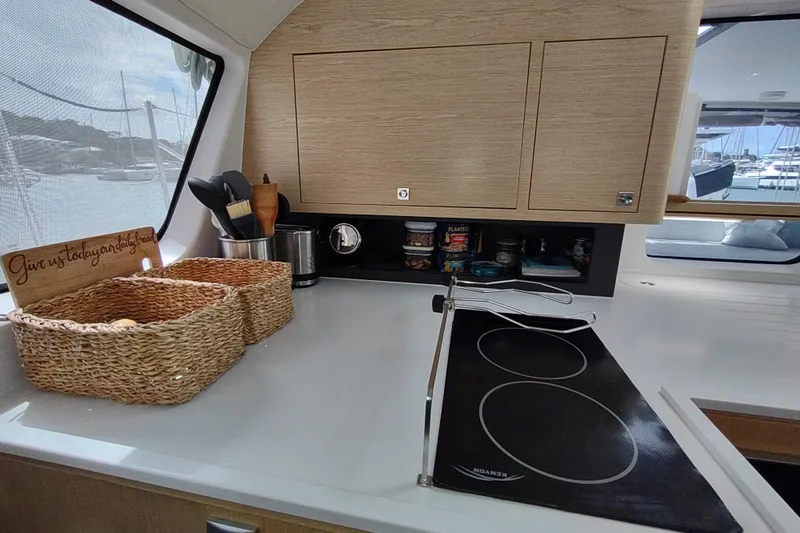 Slide: The Image of Modern kitchen in 2020 Outremer 51 yacht with stove, baskets, and scenic window view. - 61