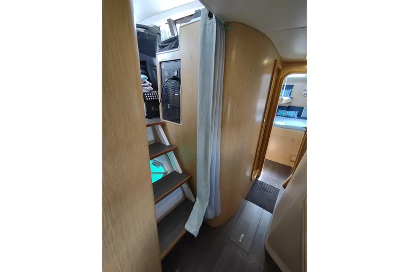 Slide: The Image of Interior of 2020 Outremer 51 yacht, featuring wooden stairs and cozy cabin space. - 63