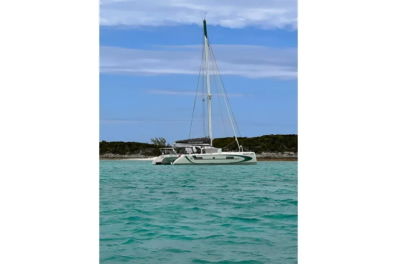 Slide: The Image of 2020 Outremer 51 catamaran sailing in turquoise waters under a clear sky. - 9