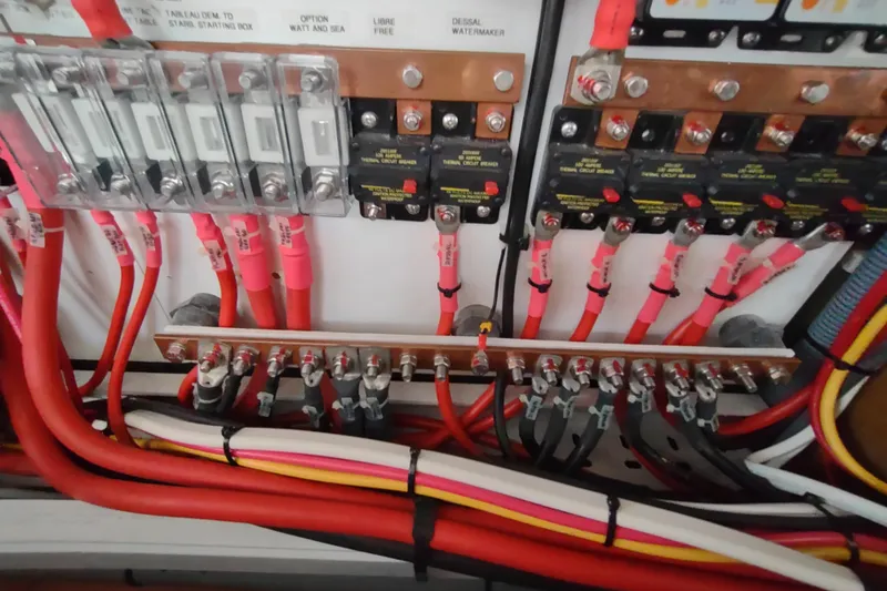 Slide: The Image of Electrical panel with red and yellow wires in a 2020 Outremer 51 boat. - 98