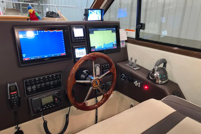 Slide: The Image of 2017 Cutwater C-30 Sedan helm with navigation screens, wooden steering wheel, and control panel. - 54