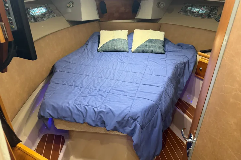 Slide: The Image of Cozy cabin interior of 2017 Cutwater C-30 Sedan with blue bedding and pillows. - 50
