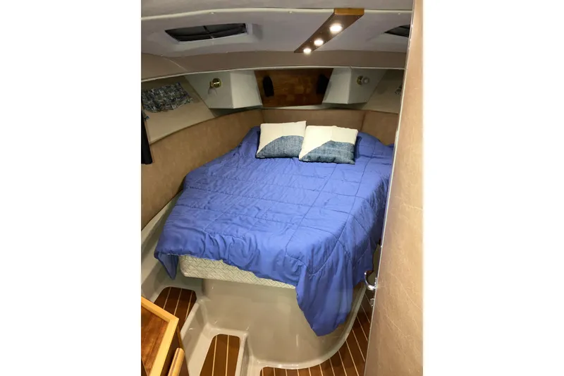 Slide: The Image of 2017 Cutwater C-30 Sedan cabin with blue bedding and wooden flooring. - 76