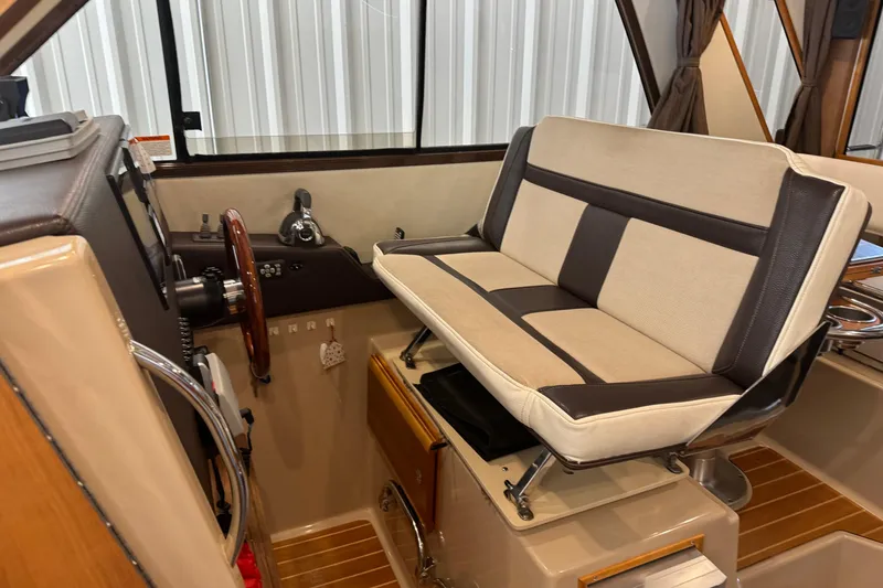 Slide: The Image of Interior of a 2017 Cutwater C-30 Sedan boat with beige and brown seating. - 46