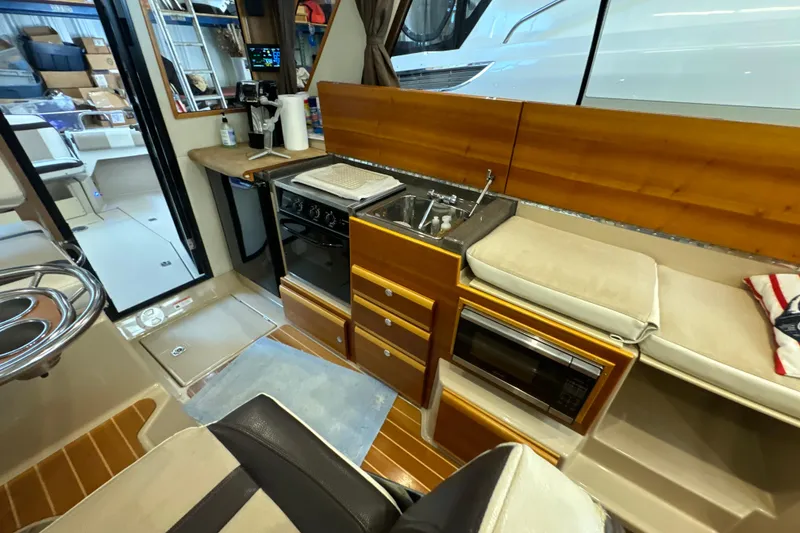 Slide: The Image of Interior of a 2017 Cutwater C-30 Sedan yacht featuring a compact kitchen area. - 31