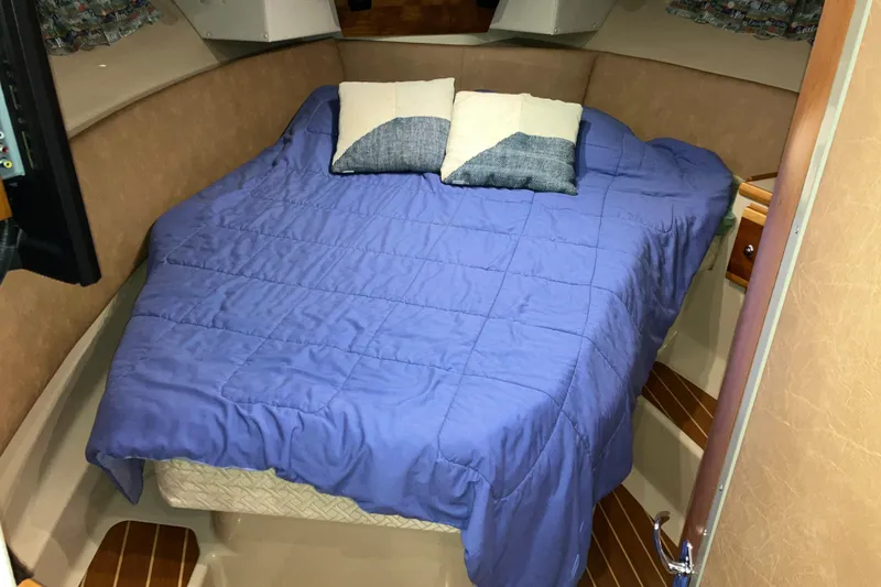 Slide: The Image of 2017 Cutwater C-30 Sedan cabin with blue bedding and pillows. - 77