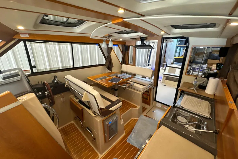 Slide: The Image of Interior of 2017 Cutwater C-30 Sedan boat, featuring helm, seating, and kitchenette. - 23